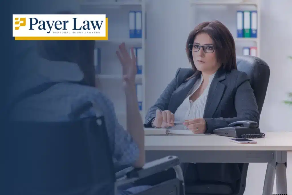 a woman wearing glasses sitting and looking at an injured person